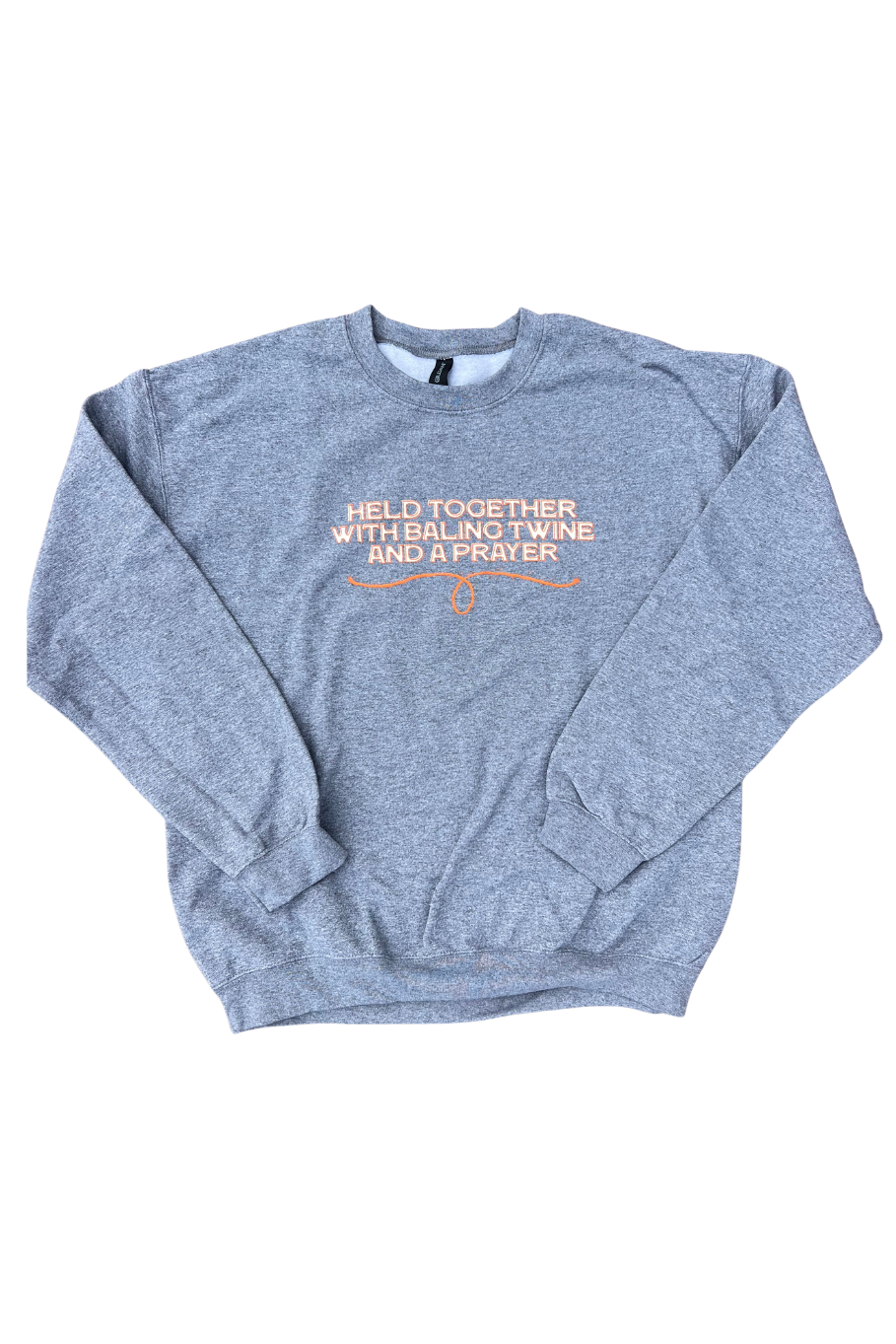 A heather gray crewneck sweatshirt with orange printed text on the chest reading 'HELD TOGETHER WITH BALING TWINE AND A PRAYER' shown flat on a white background.
