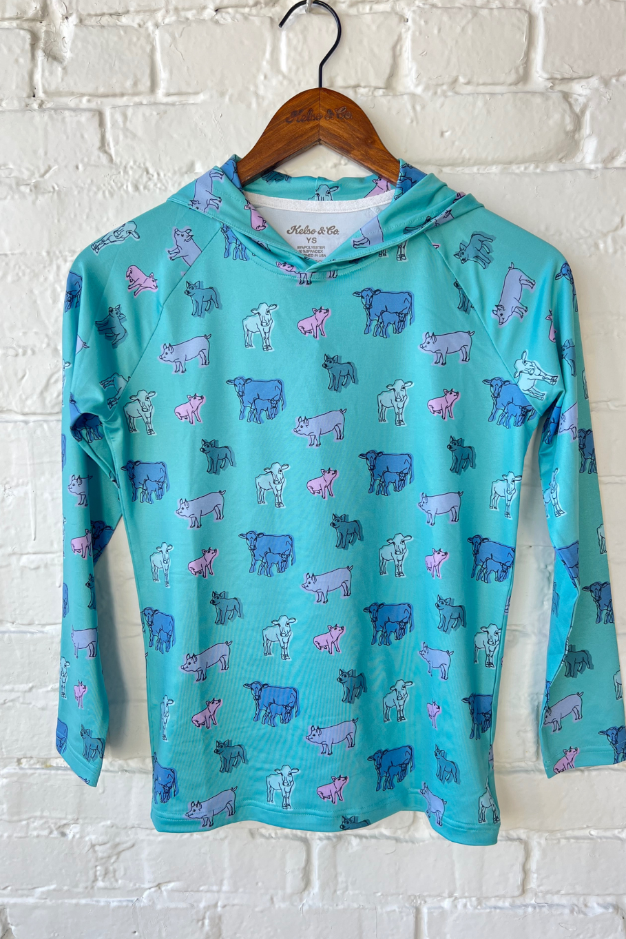 Youth performance hoodie with teal background and a pink, purple, and blue livestock pattern featuring pigs and cattle.