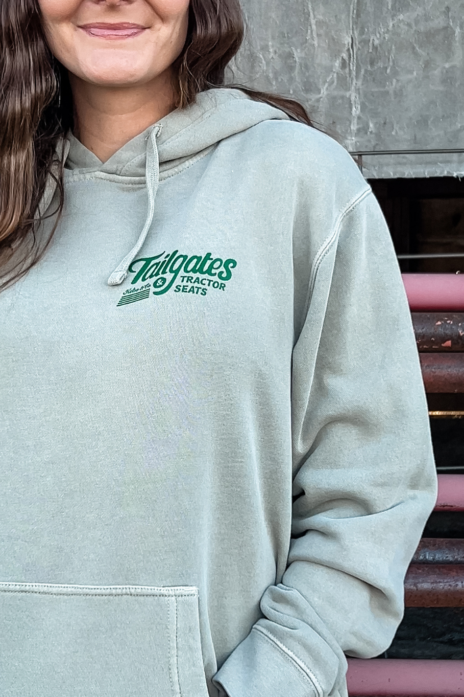 a close up of the hoodie tailgates and tractor seats on a woman with her hands in the hoodies pockets