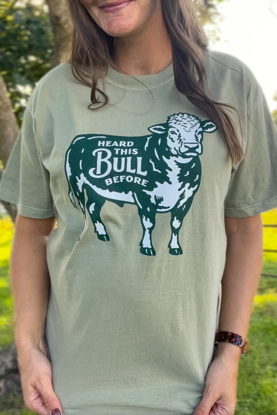 khaki comfort colors tshirt with a green and ivory bull that says heard this bull before