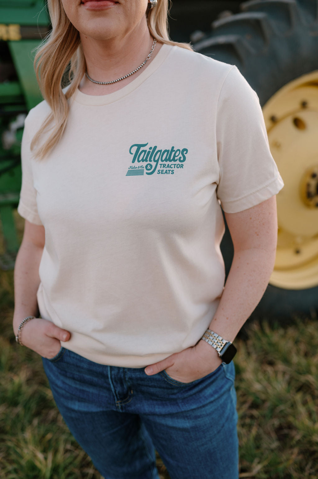 girl wearing a graphic tshirt that says tailgates and tractor seats on the left chest