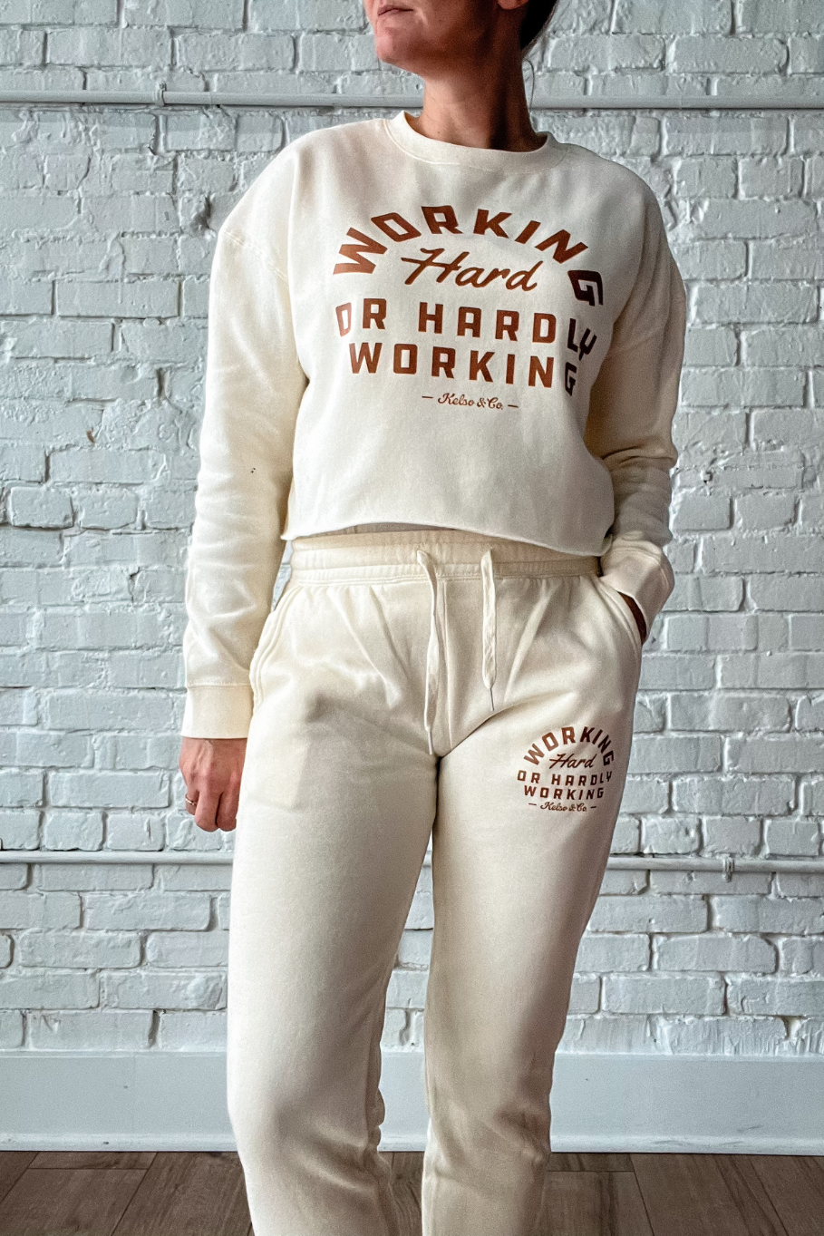 girl wearing a matching sweatshirt and joggers set in bone with brown print working hard or hardly working
