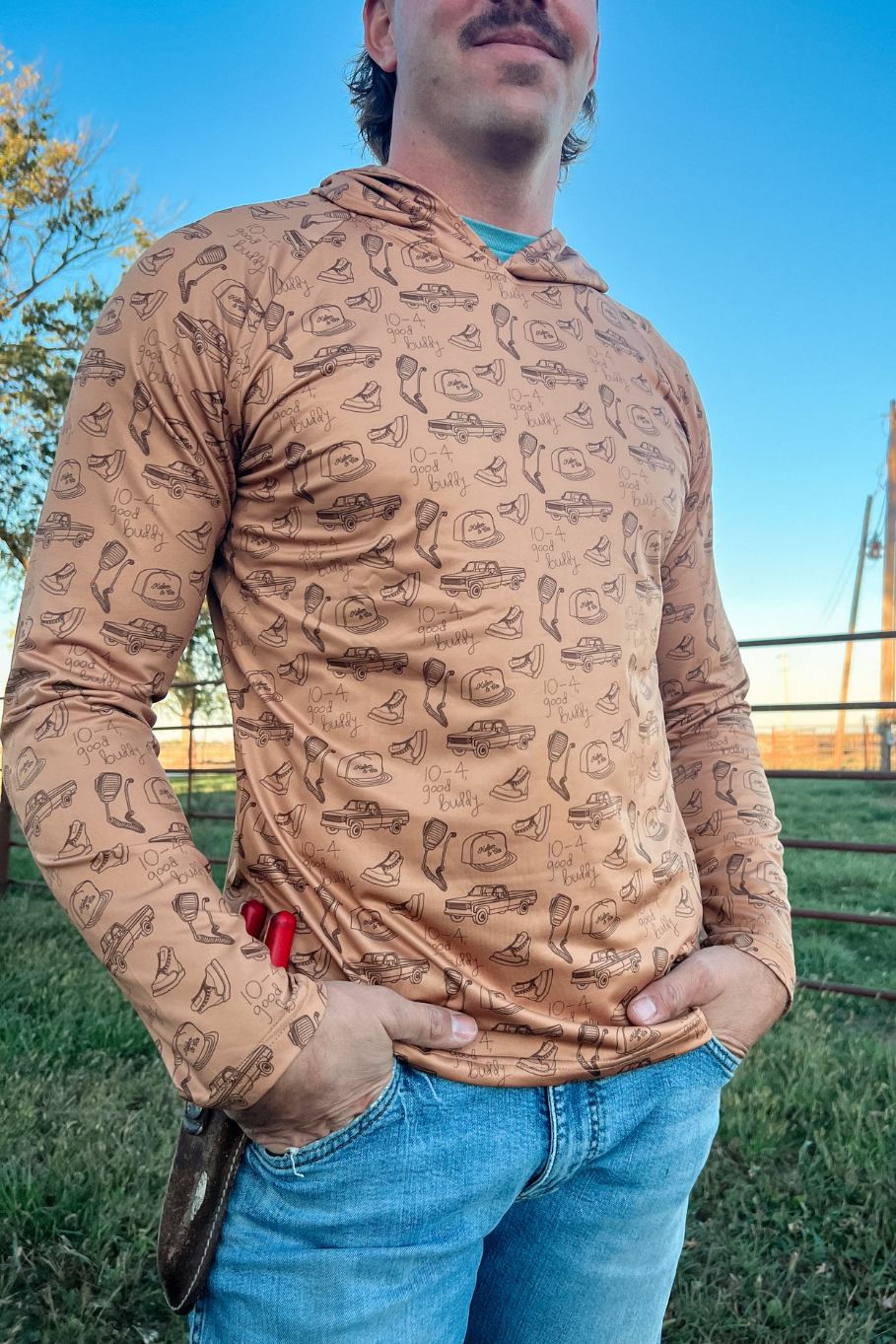 Man standing on a farm with a performance hoodie on with vintage cb radios and trucks