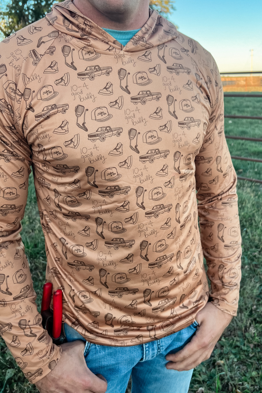 Man standing on a farm with a performance hoodie on with vintage cb radios and trucks