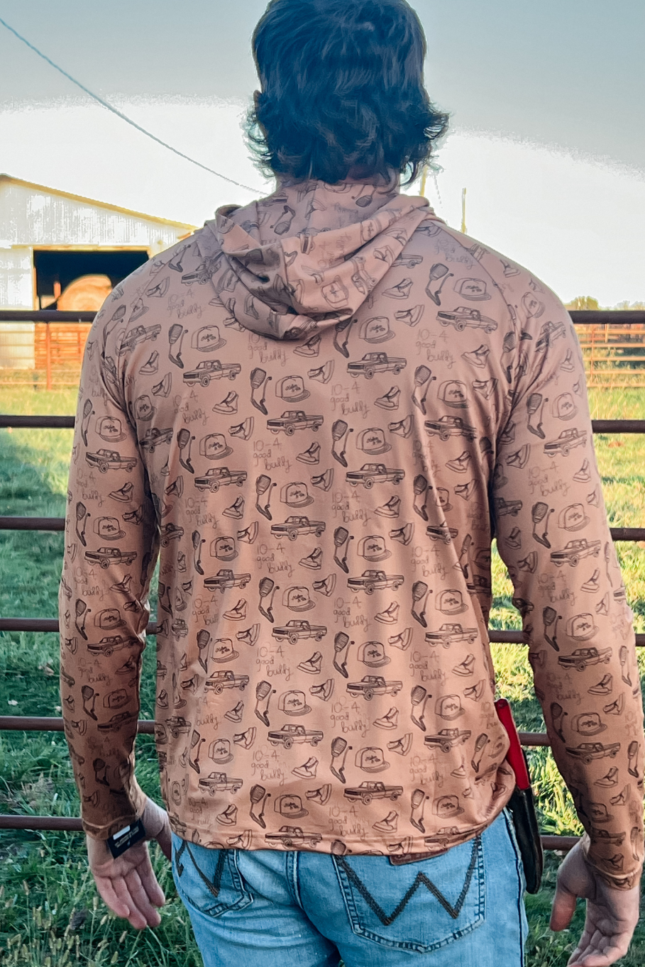 back of man standing on a farm with a performance hoodie on with vintage cb radios and trucks