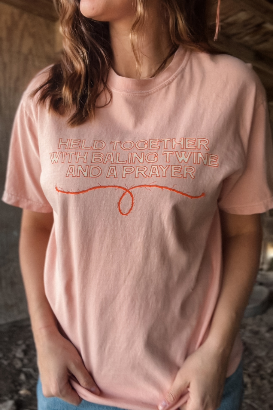 Held together with baling twine and a prayer western graphic tee in peach