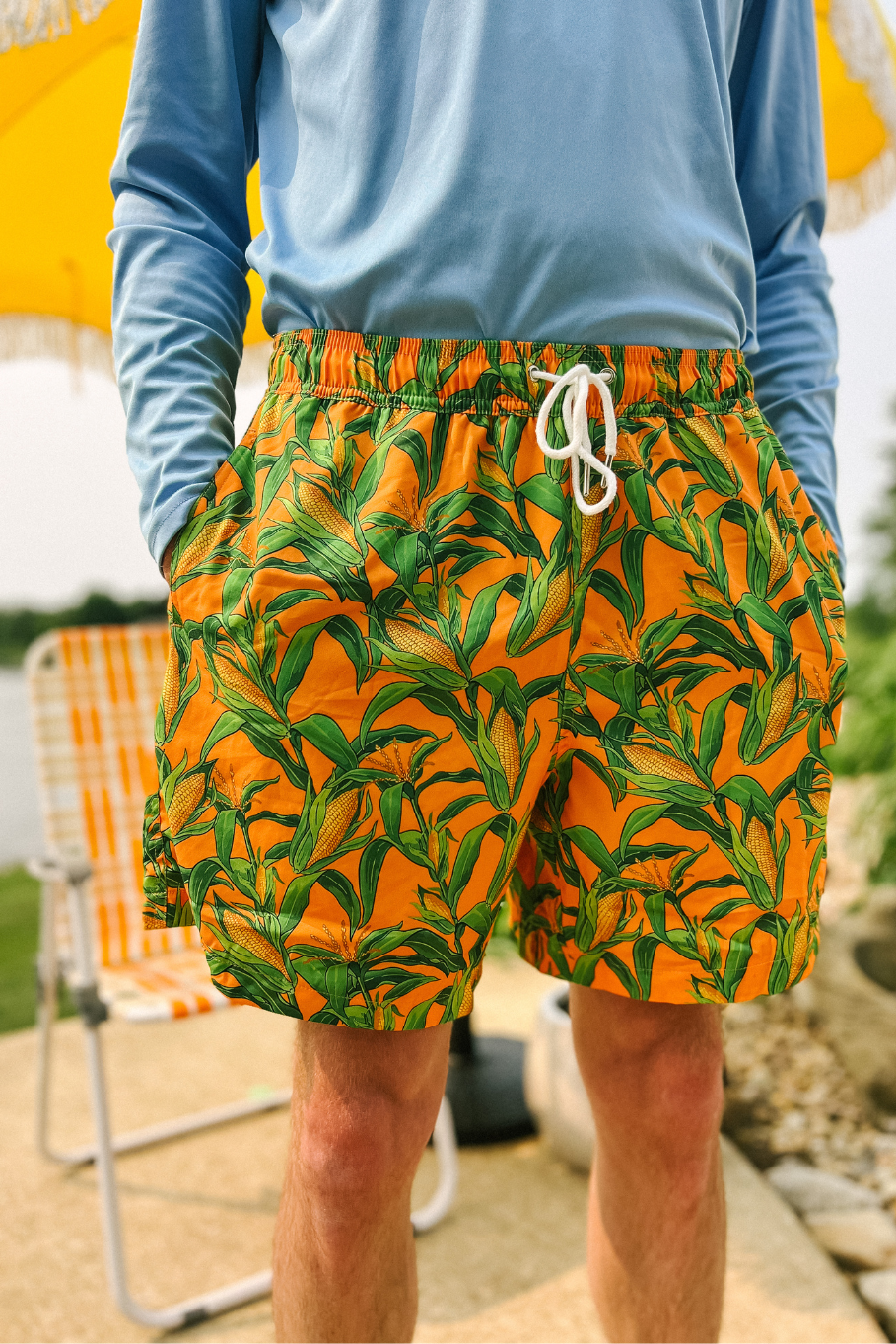 man standing with hands in pockets of corn on the cabana orange swim trunks