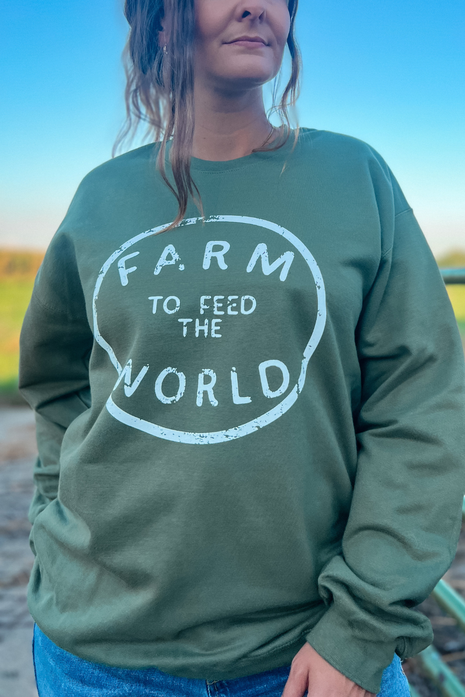 girl wearing unisex crewneck in military green that says farm to feed the world