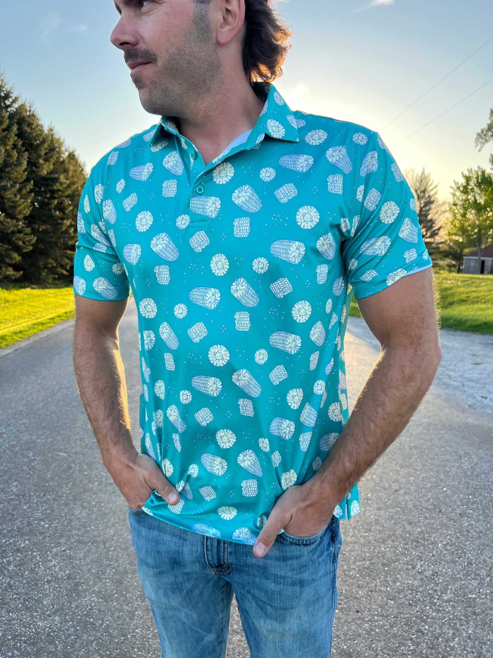 Man wearing sea green polo with scattered corn cob print.