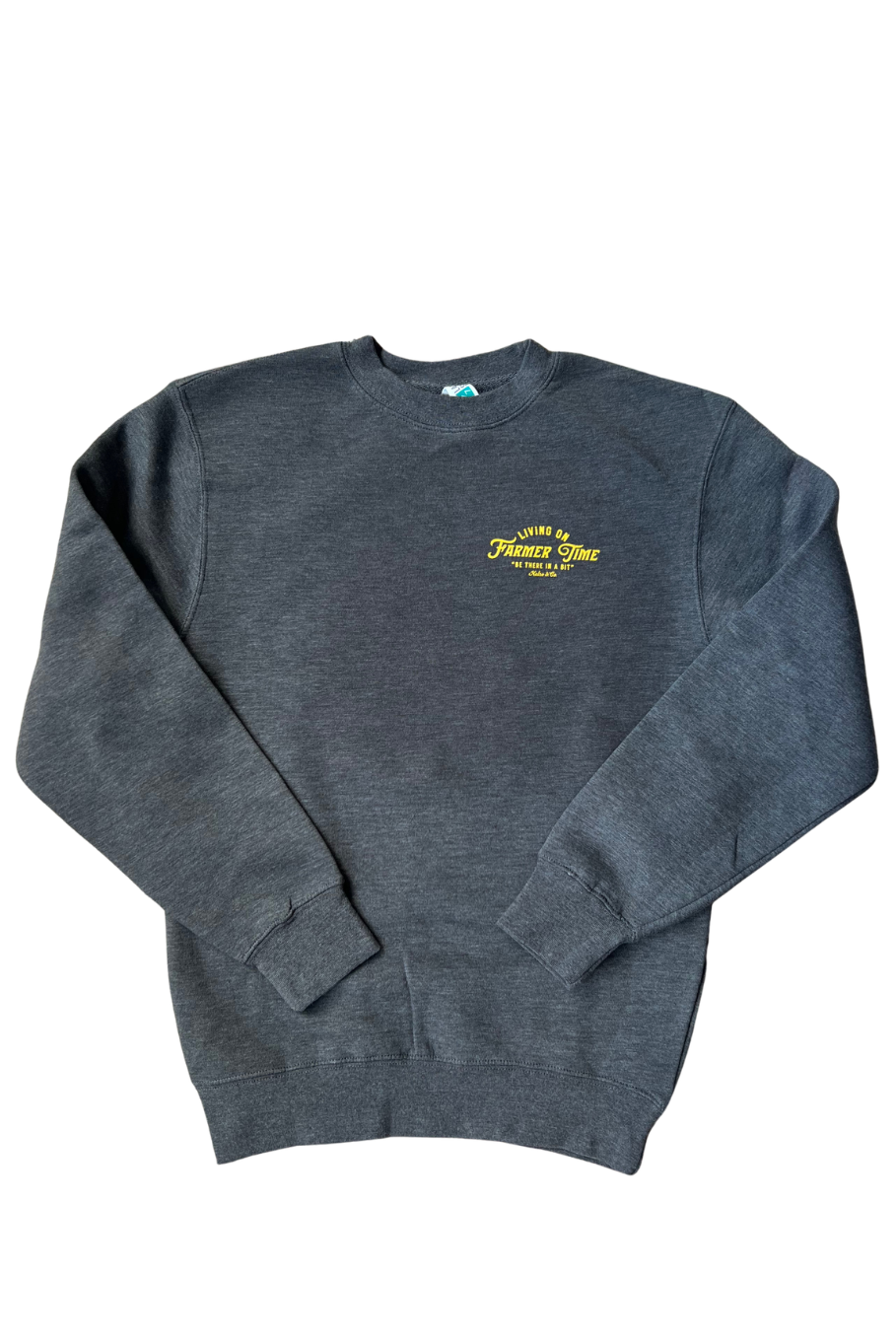 A dark heather gray crewneck sweatshirt with a small yellow graphic on the left chest reading 'Living on Farmer Time', displayed flat against a white background.
