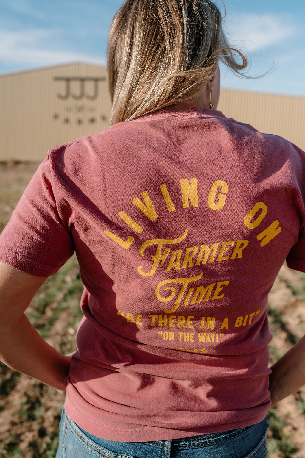 woman wearing the brick living on farmer time tshirt in a yellow graphic