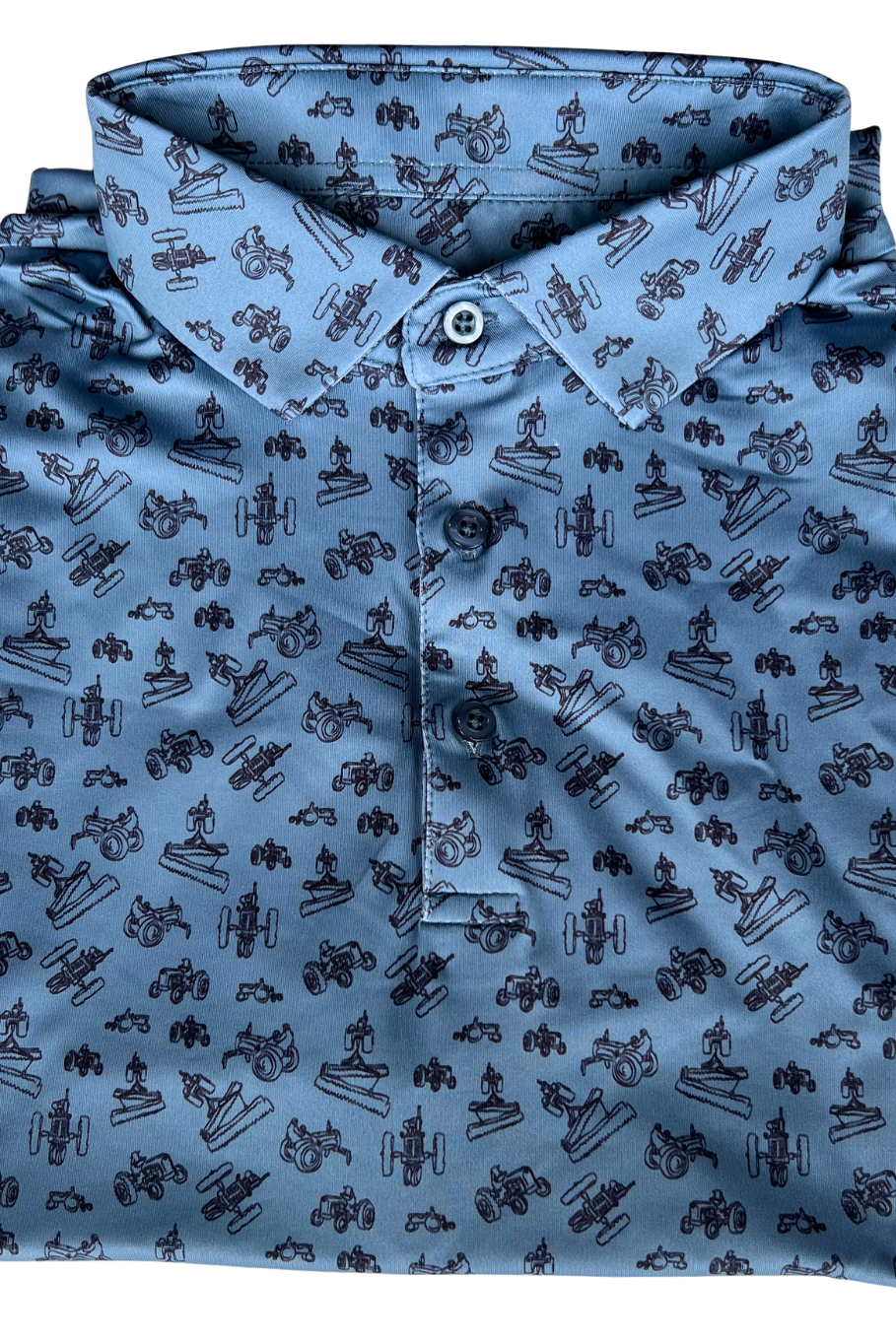 Close up flat lay of the front of a blue polo with a scattered vintage tractor design. 