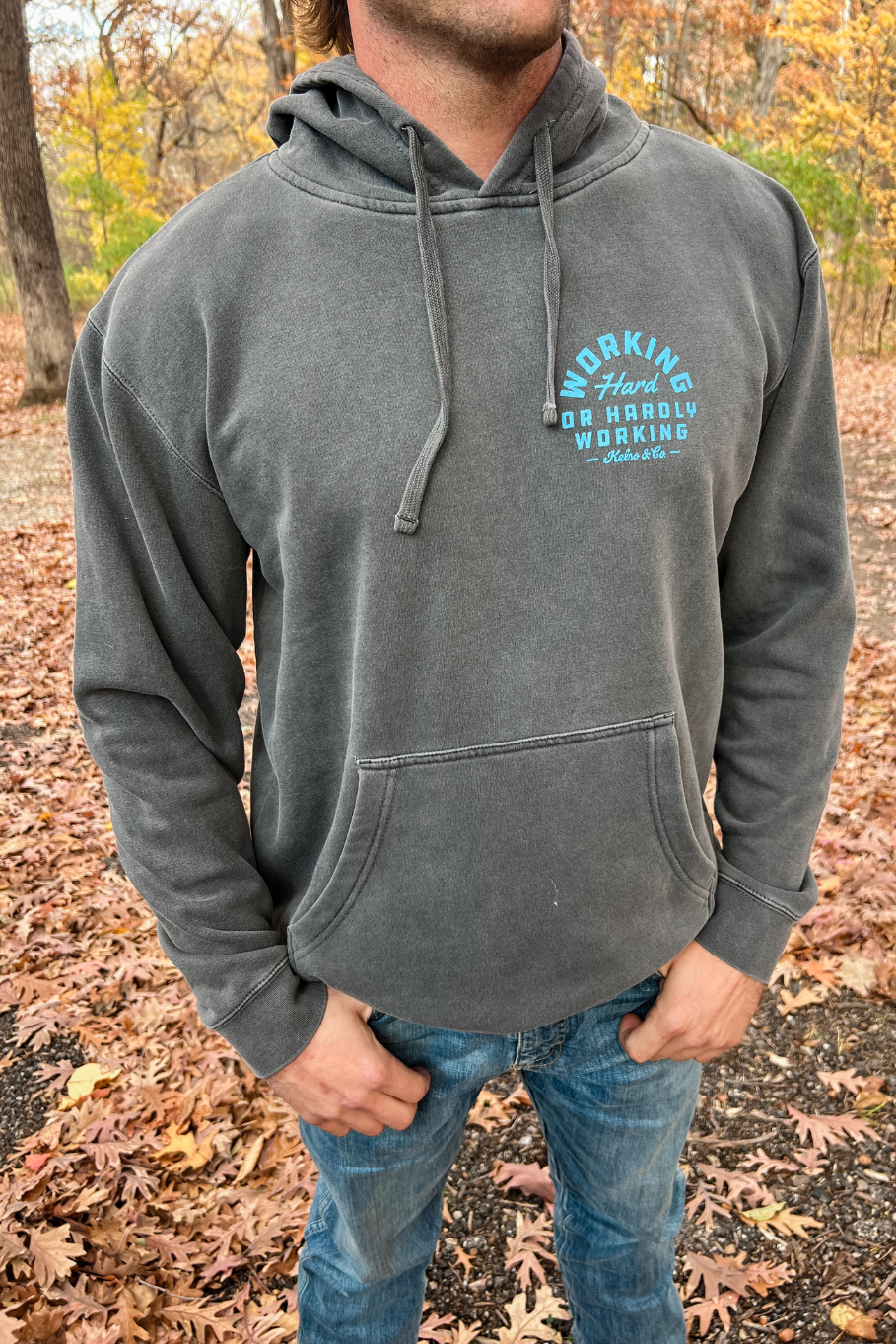 guy wearing pigmented black hoodie with working hard hardly working graphic left chest