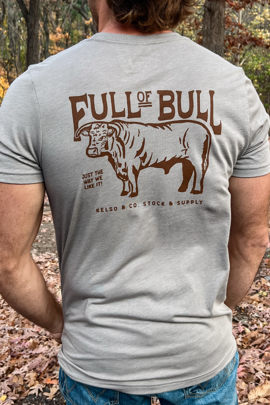 guy wearing a solid gray t-shirt with a graphic of a bull with the words "full of bull, kelso and co stock and supply"
