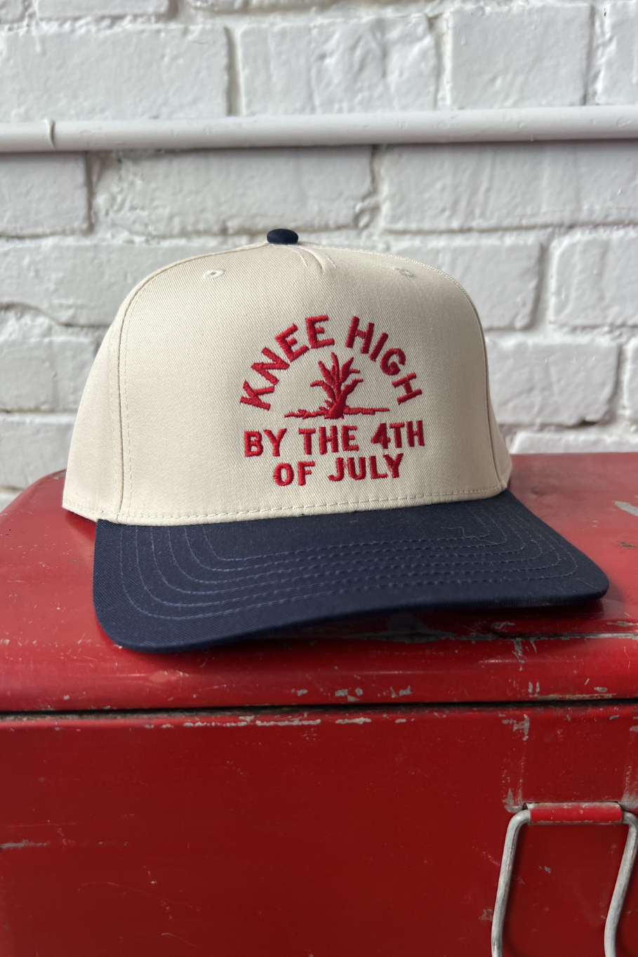 natural canvas body trucker hat with navy bill and red embroidery "knee high by the 4th of July"