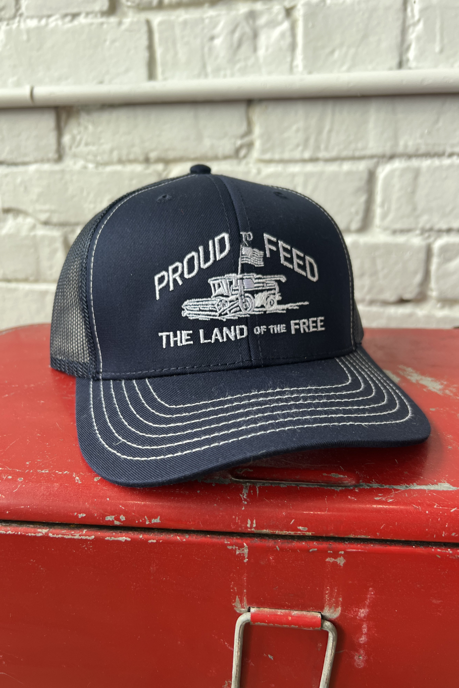 navy blue mesh back hat with proud to feed the land of the free