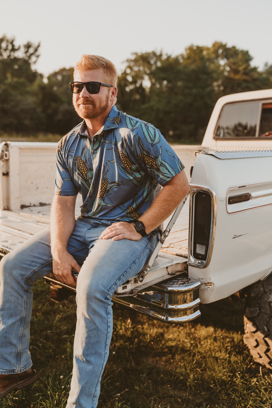 men's shuck yeah corn polo sitting on tailgate of vintage truck