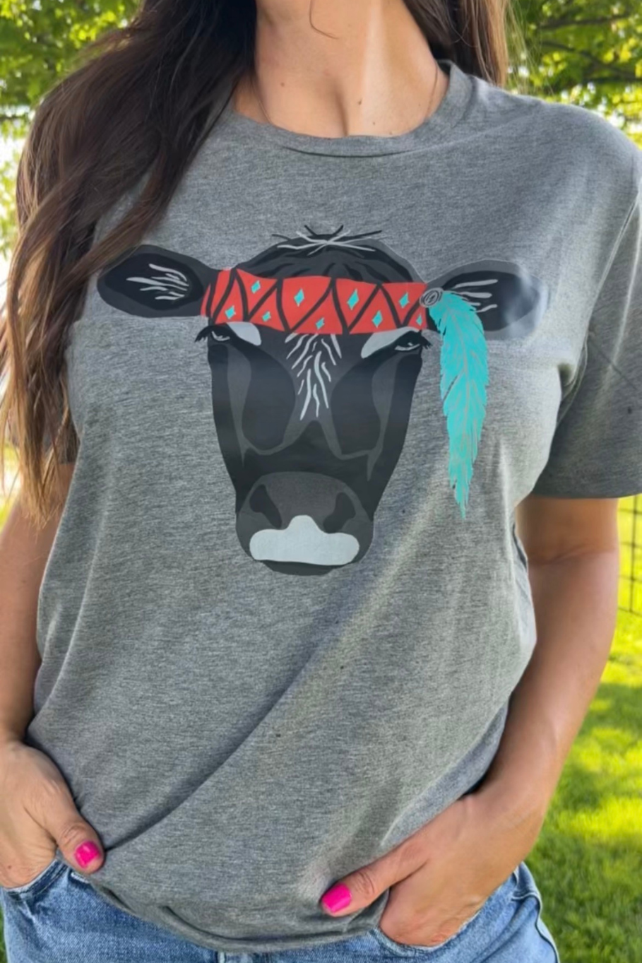 women's gray triblend graphic tee with a black cow face with a red band across her forehead and a feather hanging down from her left ear