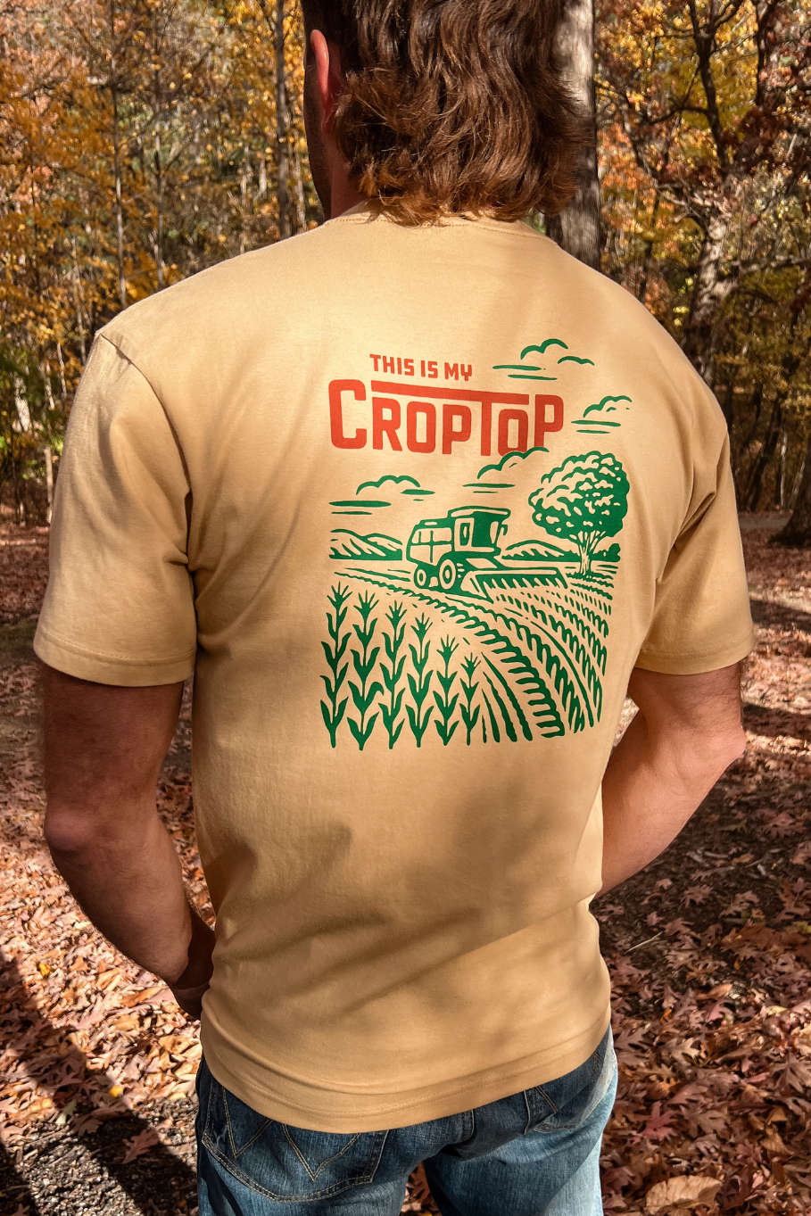 back of guy wearing light camel shirt that says this is my crop top with a graphic of a combine harvesting corn